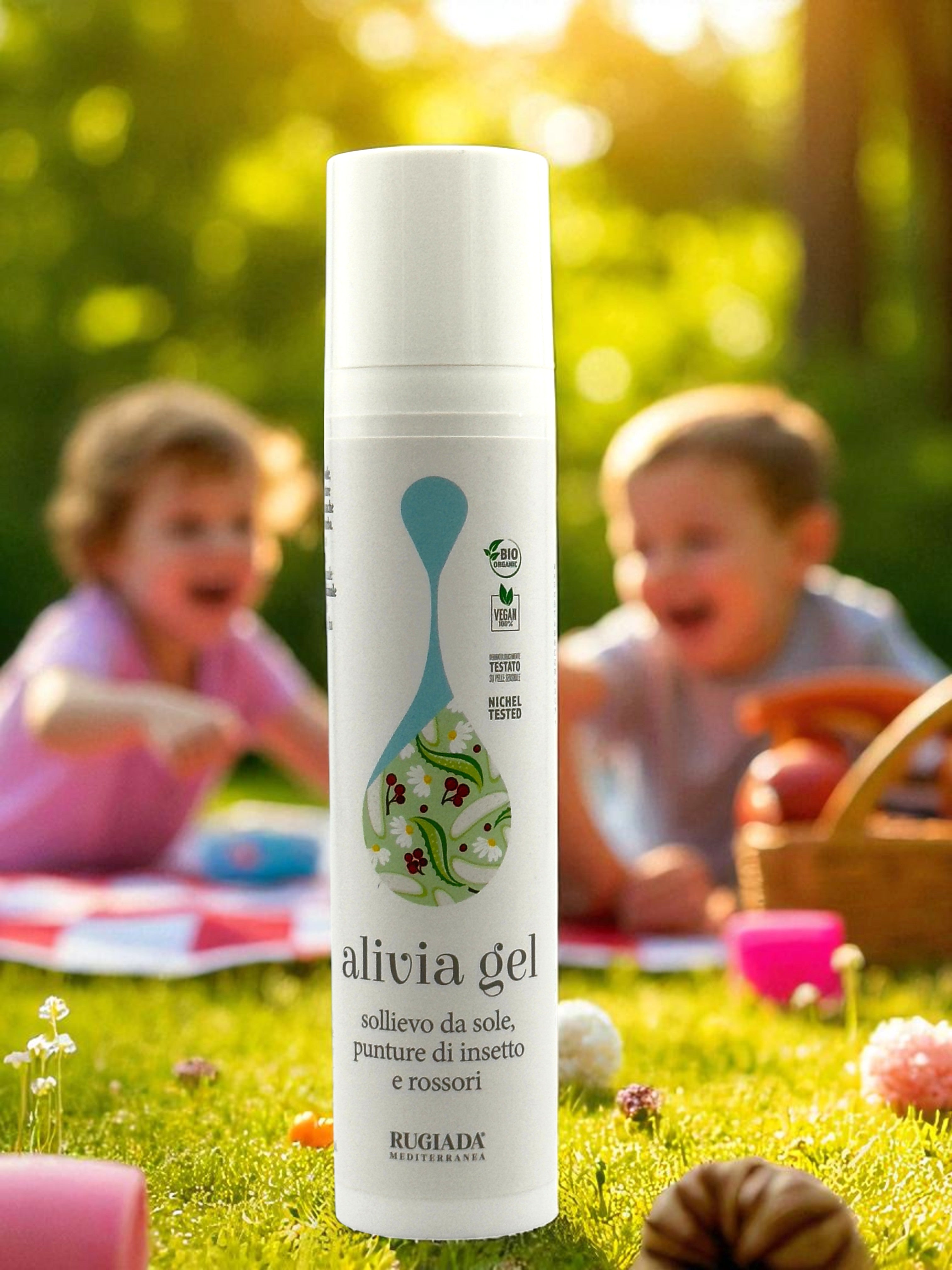 Flacone di Alivia Gel su prato con bambini che giocano sullo sfondo.